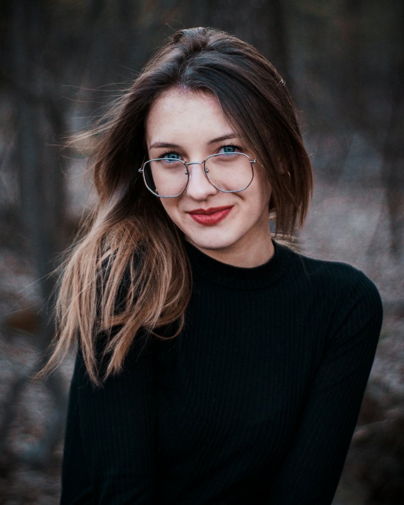 Mulher sorrindo ao ar livre usando óculos novos