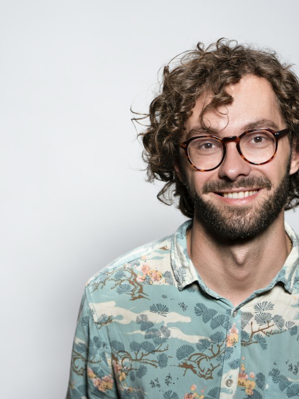 Homem sorrindo de óculos redondos