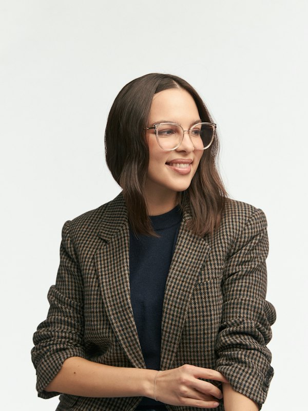 Mulher sorrindo de blazer e óculos